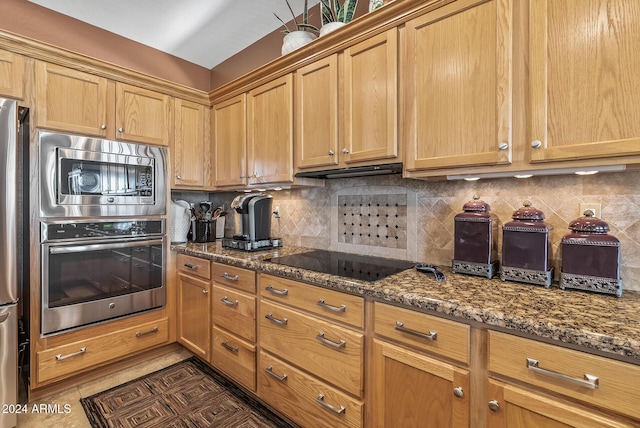 kitchen featuring dark stone countertops, backsplash, and appliances with stainless steel finishes