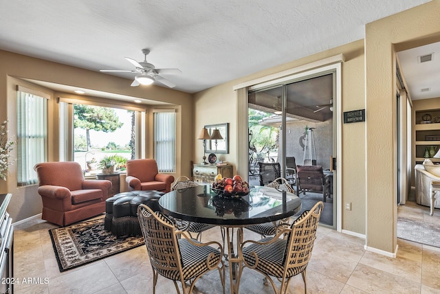 dining area with ceiling fan, light tile patterned floors, a healthy amount of sunlight, and a textured ceiling