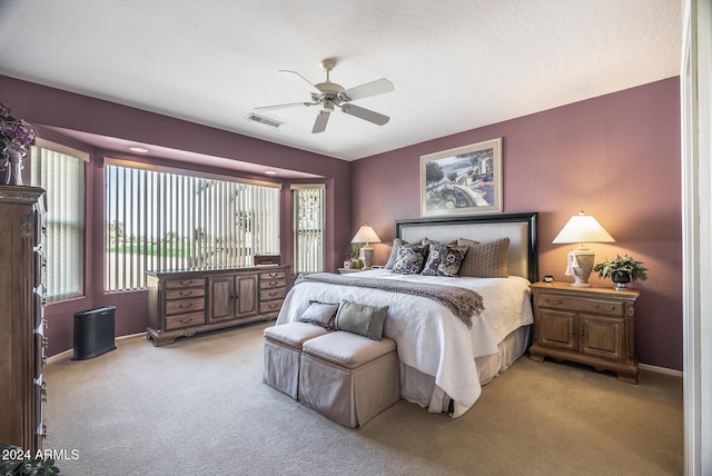 carpeted bedroom with multiple windows and ceiling fan