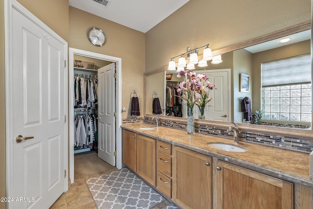 bathroom featuring tile patterned floors, decorative backsplash, and vanity