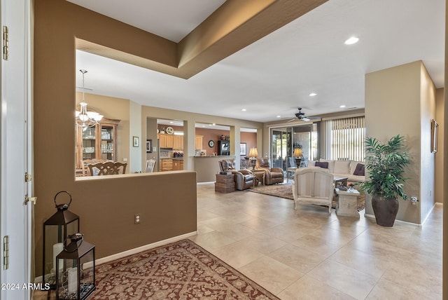 living room featuring light tile patterned floors and ceiling fan with notable chandelier