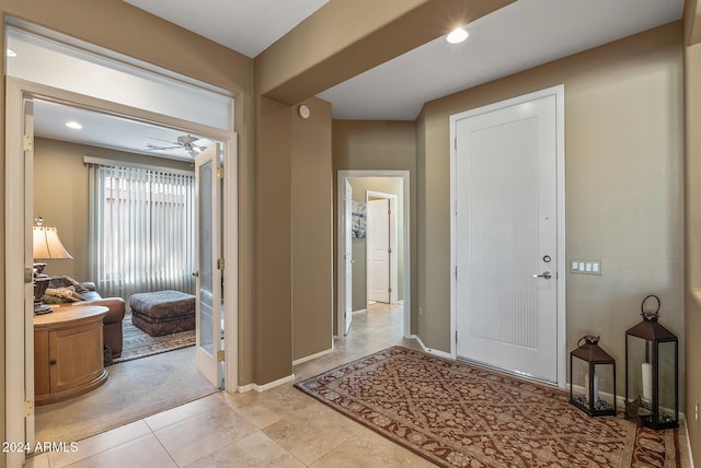 foyer featuring ceiling fan and light tile patterned flooring