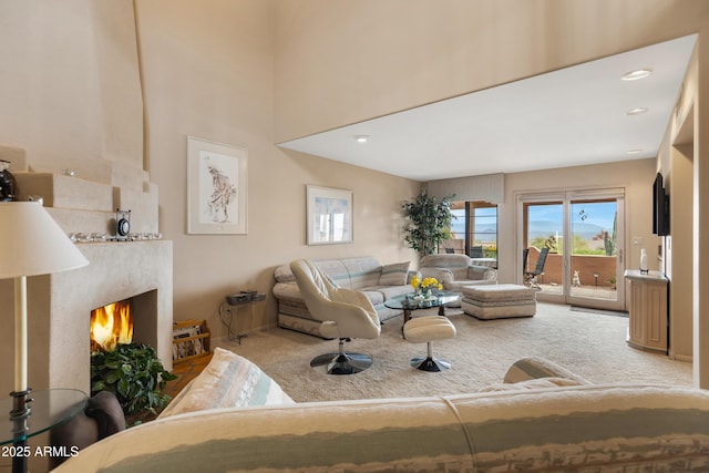 living area featuring carpet flooring and a lit fireplace