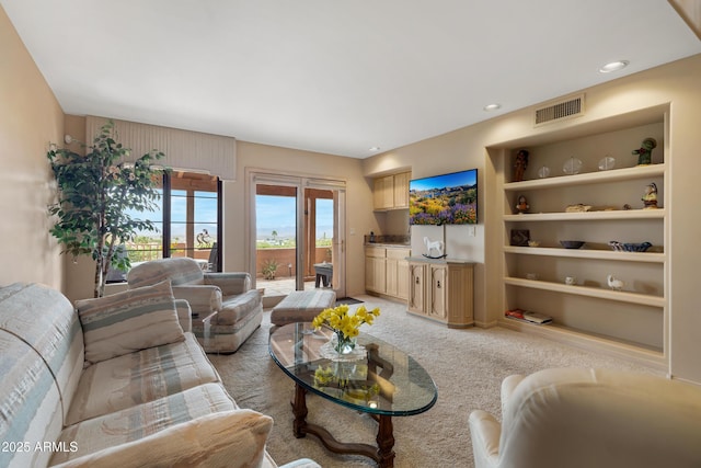 living area featuring light carpet, visible vents, recessed lighting, and built in features