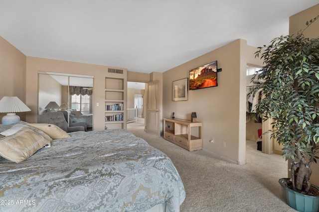 carpeted bedroom with visible vents and a closet