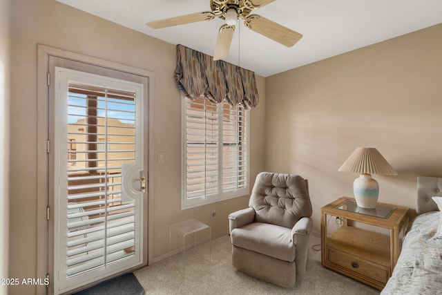 living area featuring baseboards, a ceiling fan, and carpet floors