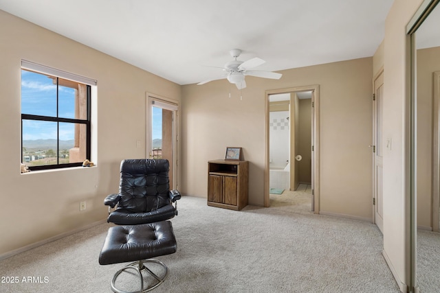 living area featuring carpet flooring, baseboards, and a ceiling fan