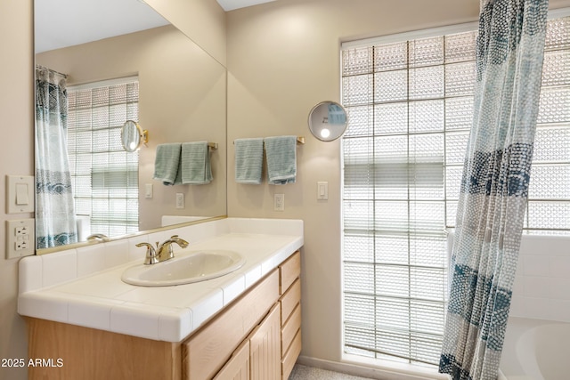 bathroom with a wealth of natural light, vanity, and shower / bath combo