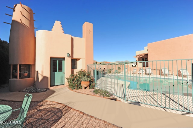 community pool featuring a patio and fence