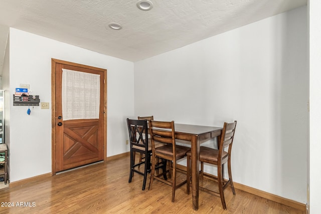 dining room featuring hardwood / wood-style floors and a textured ceiling