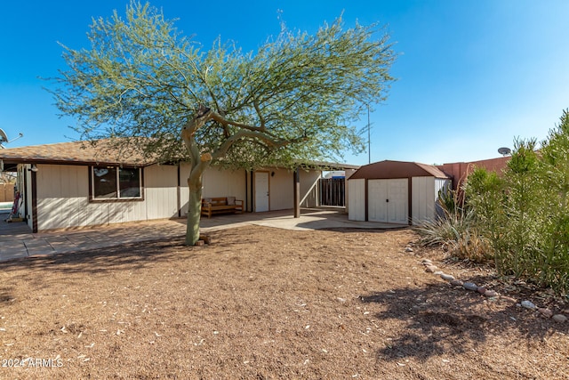 rear view of house featuring a shed and a patio