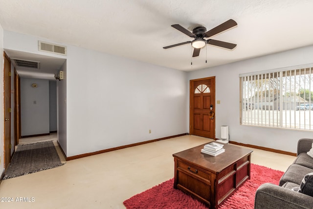 living room with ceiling fan, a textured ceiling, and light carpet