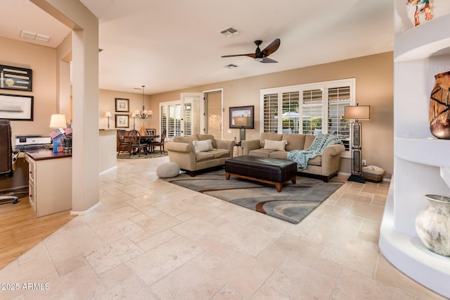 living room featuring ceiling fan with notable chandelier