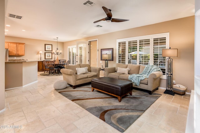 living room featuring plenty of natural light and ceiling fan with notable chandelier