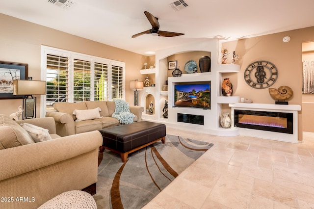 living room with built in features and ceiling fan