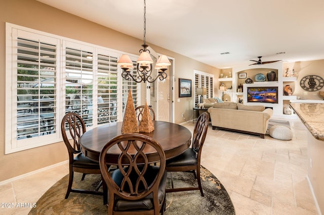 dining room with built in shelves and ceiling fan with notable chandelier