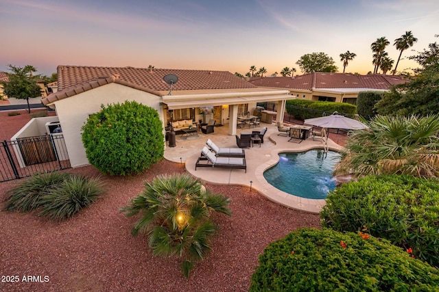 pool at dusk with outdoor lounge area and a patio area