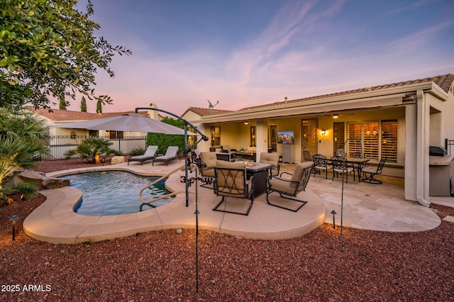 pool at dusk featuring a patio area