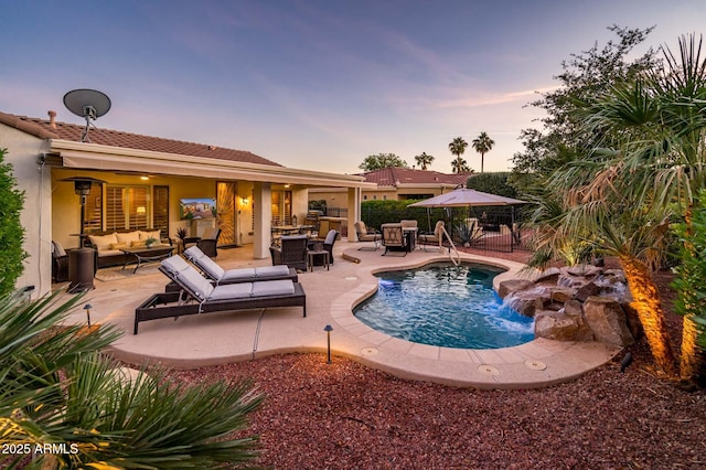 pool at dusk with an outdoor living space and a patio area