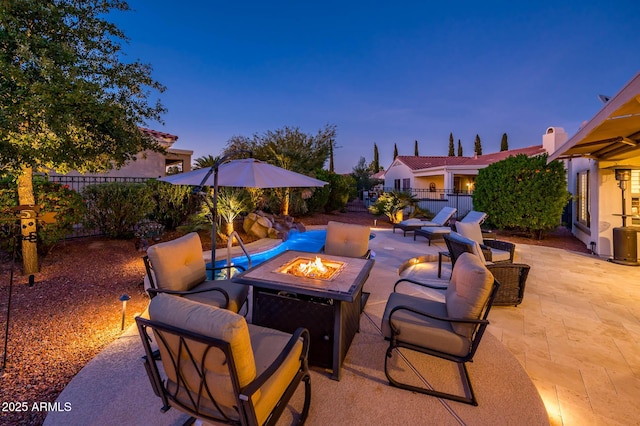 patio terrace at dusk featuring an outdoor fire pit