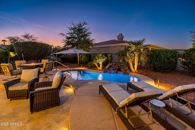 pool at dusk featuring a patio area and an outdoor fire pit