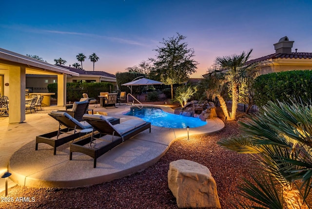 pool at dusk featuring a patio area