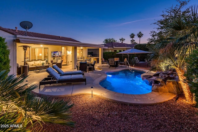 pool at dusk featuring a patio area and an outdoor living space