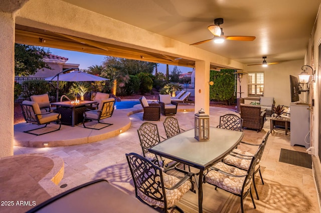 patio terrace at dusk featuring an outdoor living space with a fire pit and ceiling fan