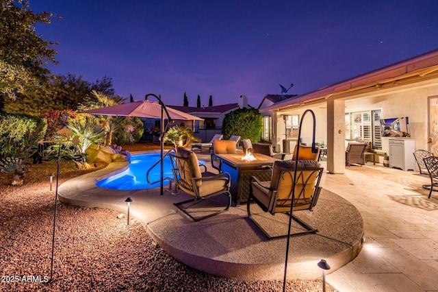 view of swimming pool with a patio and an outdoor living space with a fire pit