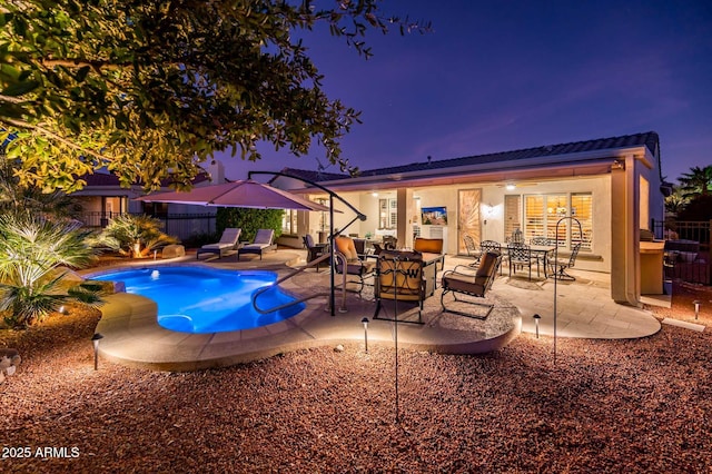 pool at dusk with a patio