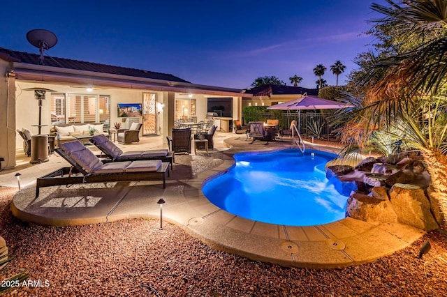 pool at dusk featuring outdoor lounge area and a patio