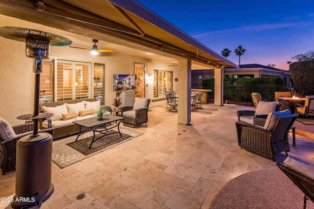 patio terrace at dusk featuring an outdoor living space with a fire pit