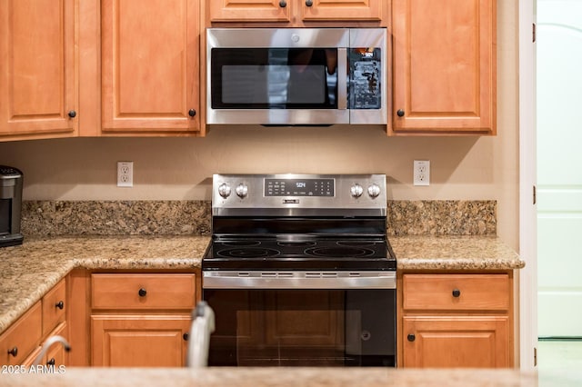 kitchen with light stone counters and stainless steel appliances