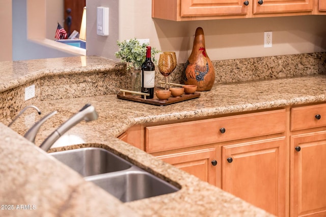 kitchen featuring light stone countertops and sink