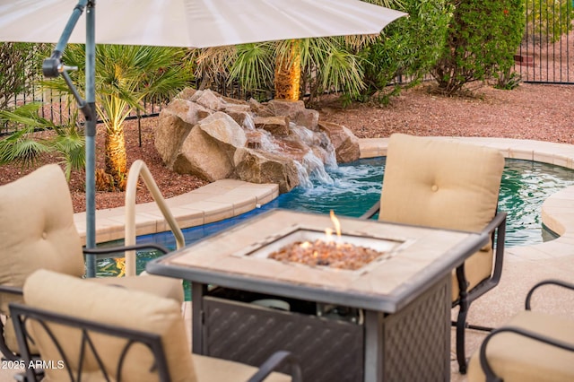 view of patio with pool water feature and an outdoor fire pit