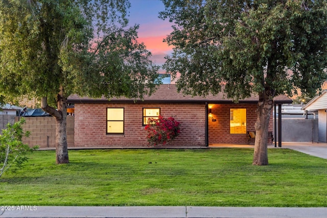 ranch-style house with fence, brick siding, and a front yard