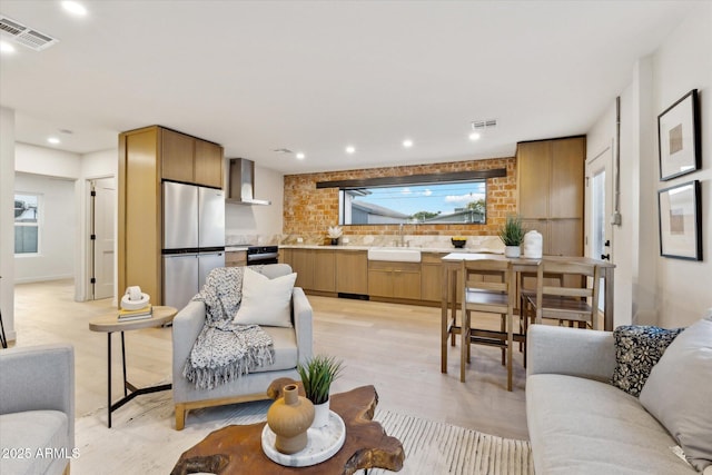 living room with light wood-style floors, plenty of natural light, and visible vents