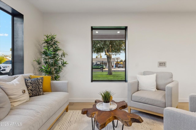 living area with recessed lighting, wood finished floors, a healthy amount of sunlight, and baseboards