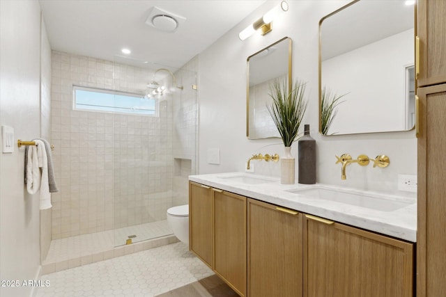 bathroom with toilet, walk in shower, a sink, and double vanity