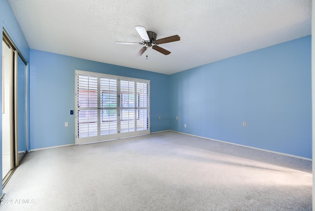 empty room with a textured ceiling, carpet floors, and ceiling fan