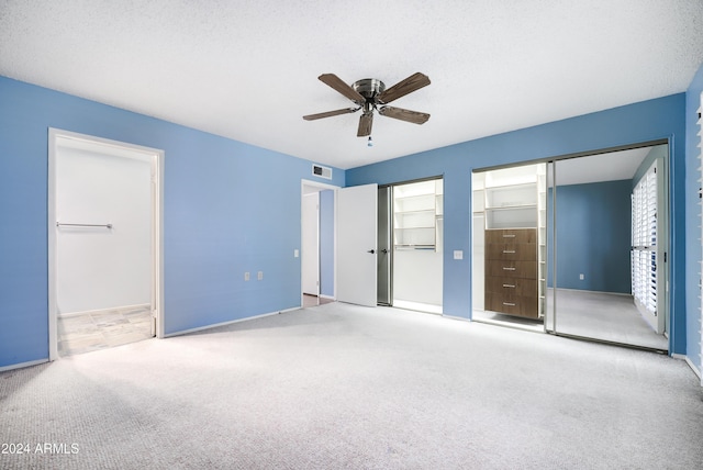 unfurnished bedroom featuring carpet, ceiling fan, and a textured ceiling