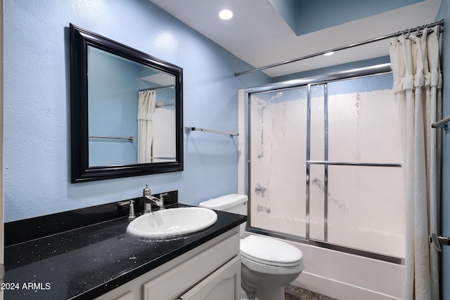 full bathroom featuring combined bath / shower with glass door, vanity, and toilet