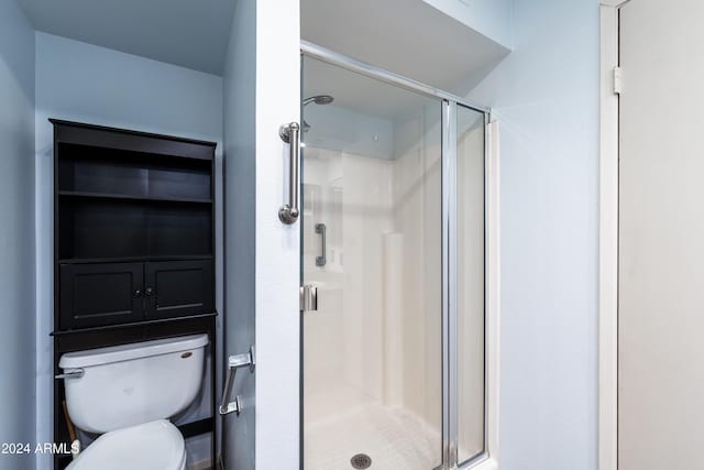 bathroom featuring toilet and an enclosed shower