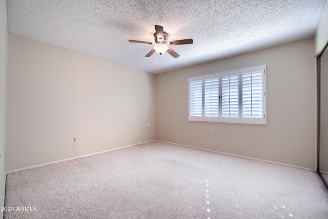 empty room with a textured ceiling, carpet floors, and ceiling fan