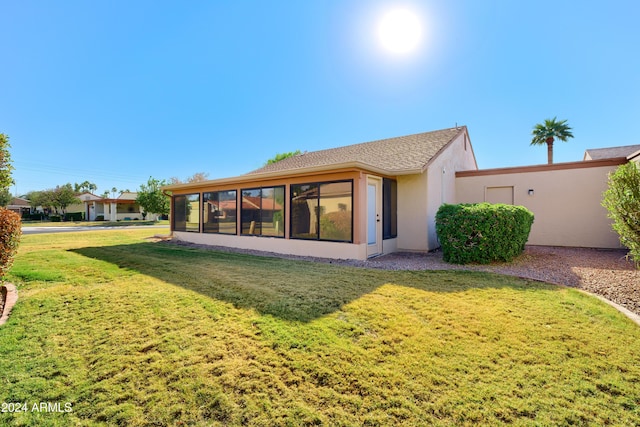 back of property with a yard and a sunroom