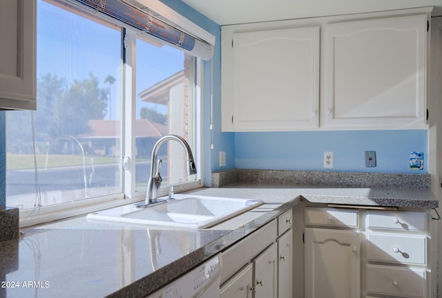 kitchen featuring sink, white cabinets, and white dishwasher