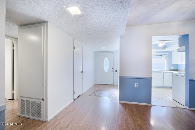 entryway featuring a textured ceiling and light hardwood / wood-style flooring