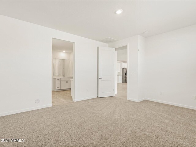 unfurnished room featuring light colored carpet