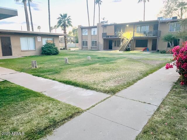 view of community featuring a lawn and stairway