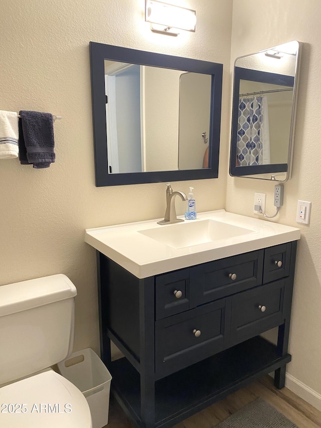 full bath with vanity, toilet, and wood finished floors